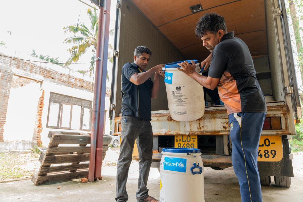Trabajadores humanitarios en Sri Lanka, descargan una donación de UNICEF de botellas de hipoclorito de calcio como parte del proceso de suministro para la respuesta a las inundaciones.